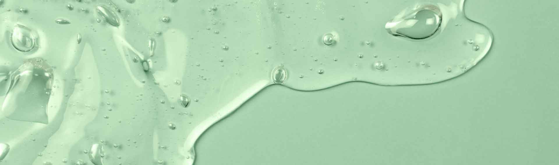 A green background with a serum texture spreading over it.