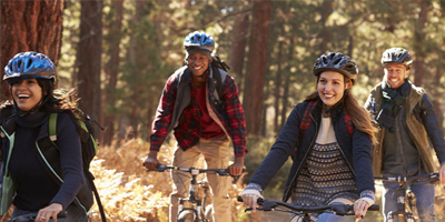 A friend group taking a bike ride on a trail during the Fall season.