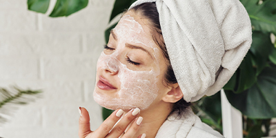 A woman cleansing her skin with one of Pevonia's foaming cleansers.