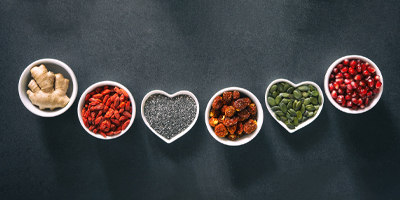 Cups of different foods and ingredients, some shaped like hearts, on a dark gray background.