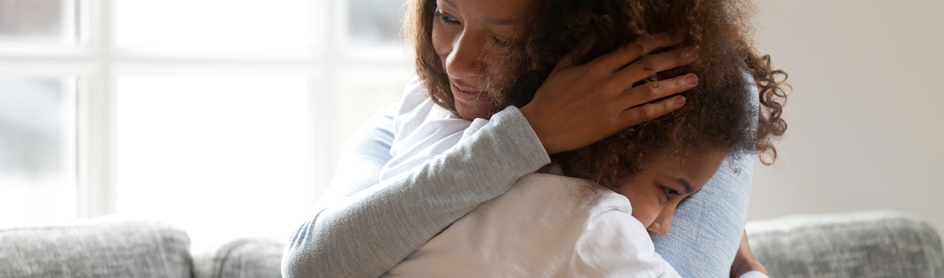 A daughter embracing her mom with a tight hug.