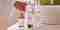Woman reaching for Pevonia Hair Energize products near her sink.